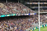 A wideshot of Perth Stadium during an AFL game with pockets of empty seating.