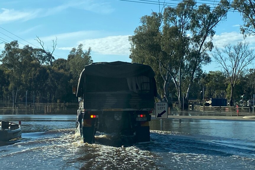 A picture of an army vehicle driving through floodwater 