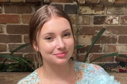 A teenaged girl smiles at the camera