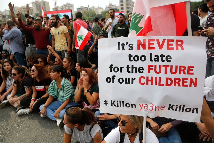 Anti-government protesters shout slogans as they block a main highway in Beirut.