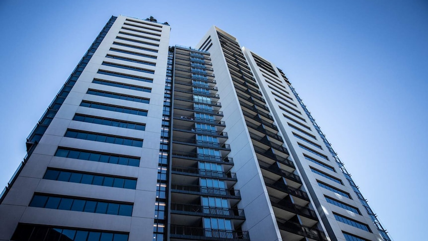 A large apartment building rises in to the sky.