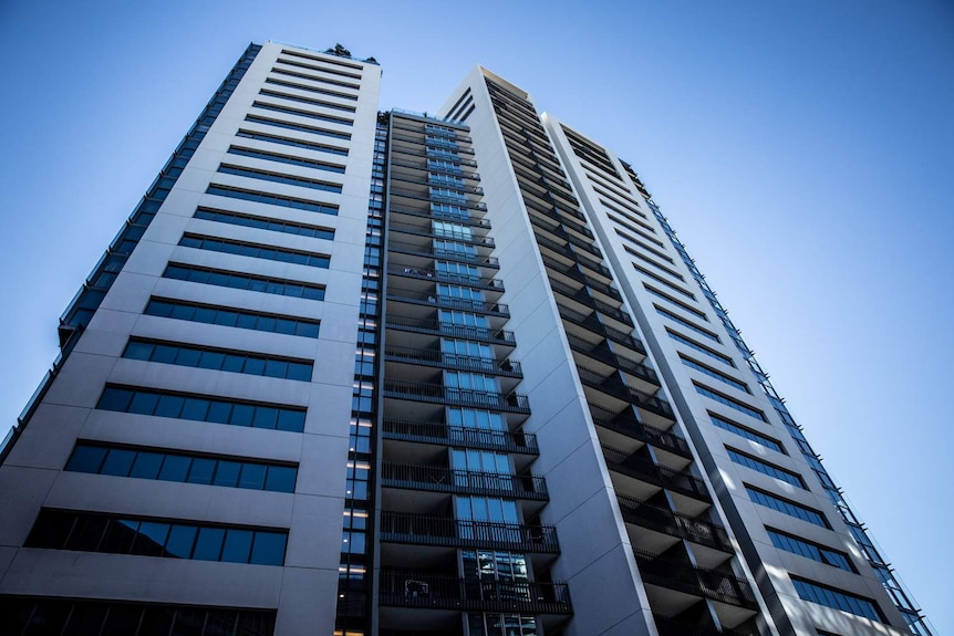 A large apartment building rises in to the sky.