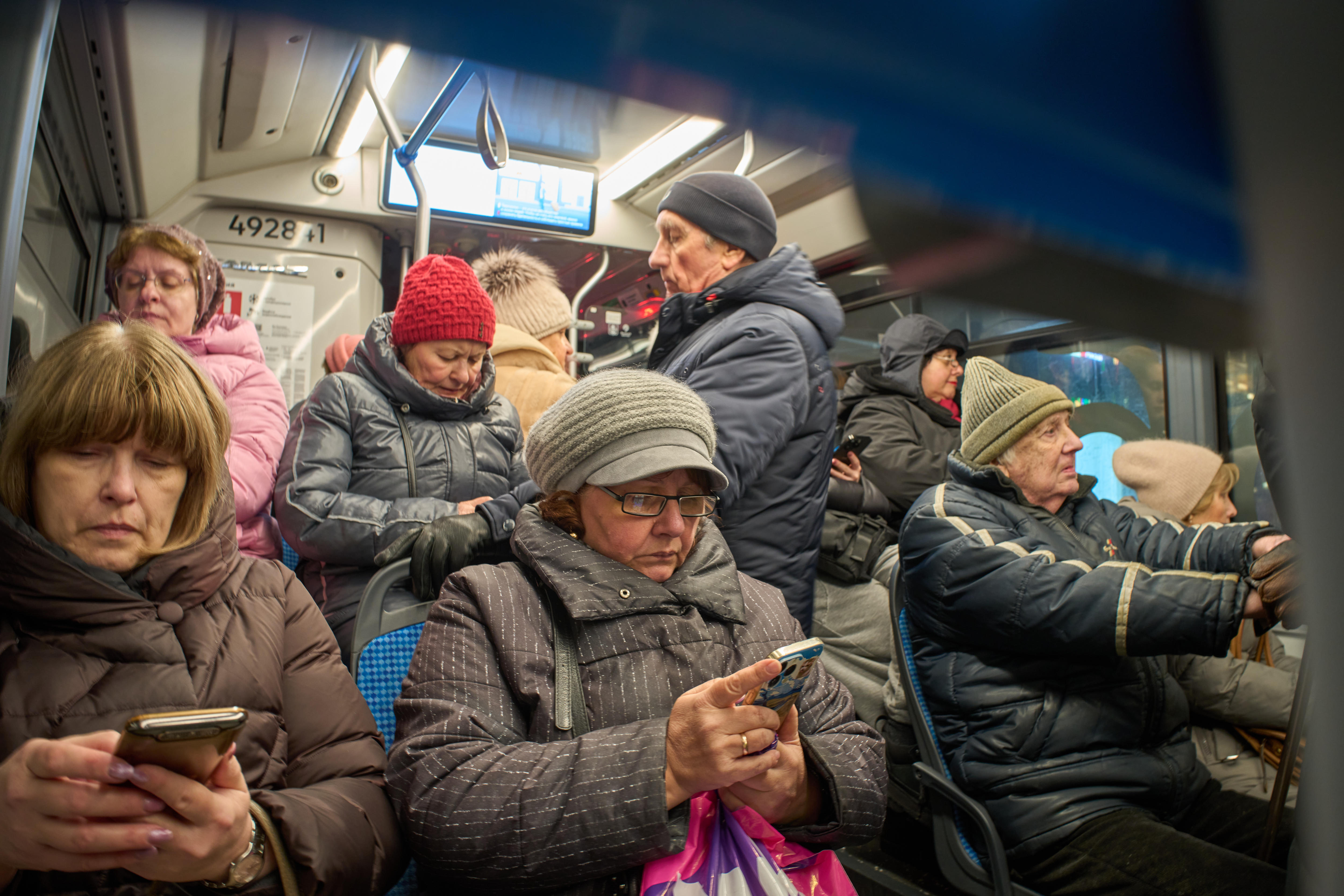 Los pasajeros de un autobús miran sus teléfonos inteligentes en Moscú