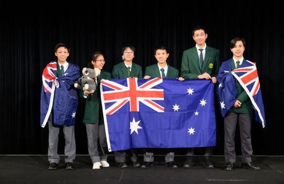 Australian students standing with an Australian flag and a toy koala.