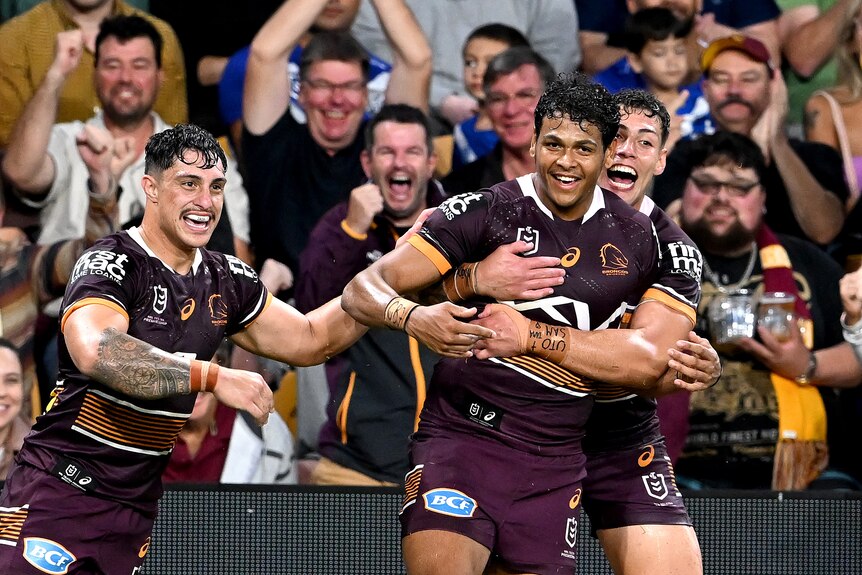 Brisbane Broncos player Selwyn Cobbo (centre) is hugged by Jordan Riki (right). Kotoni Staggs is there too.