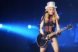 Madonna performs with a guitar onstage