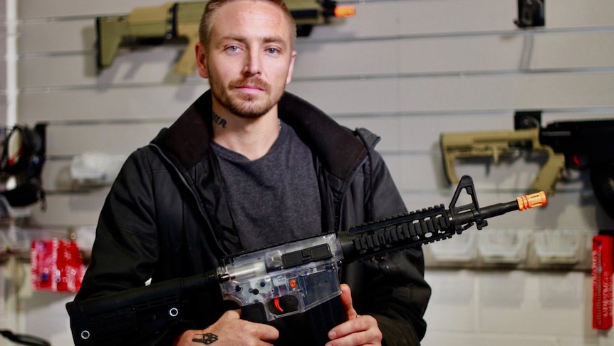 Retailer Daniel Hennessy holds a gel ball blaster, which he sells at his Brisbane shop.