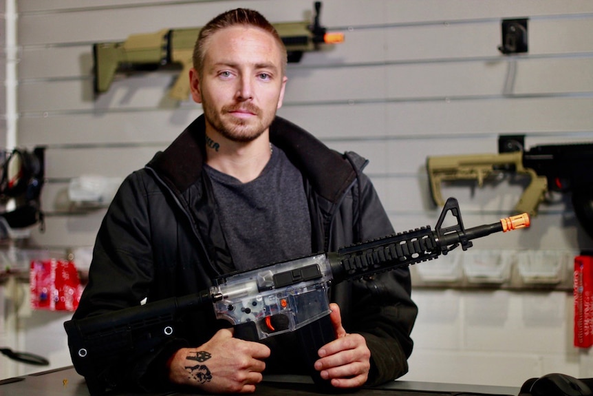 Retailer Daniel Hennessy holds a gel ball blaster, which he sells at his Brisbane shop.