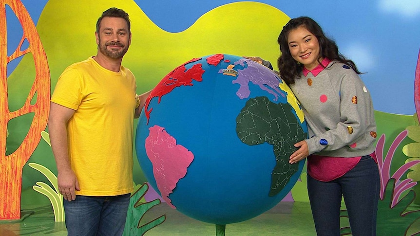 Teo and Michelle standing with a globe