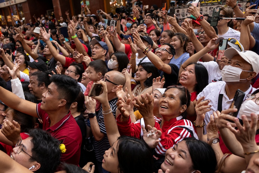 菲律宾马尼拉唐人街，人们期待现场散发的新年礼物。