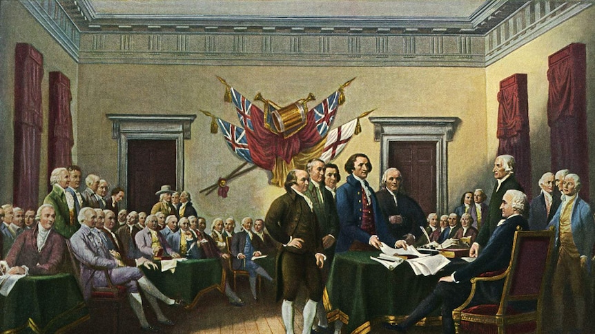 A painting of men gathering around a desk upon which sits the declaration of independence. Other men sit and look on