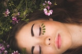 Woman lying in the grass with face paint