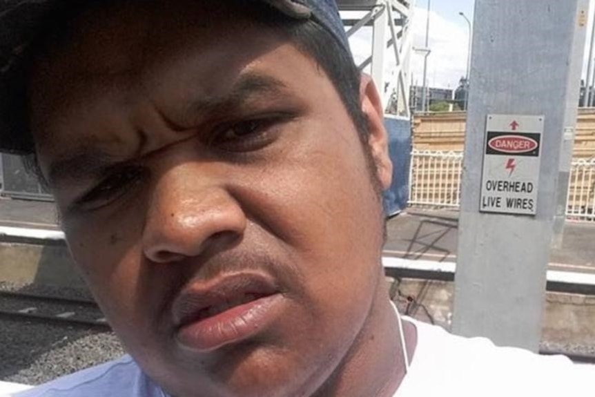 Diquan Erwin Lloyd Fisher takes a selfie near a train line.