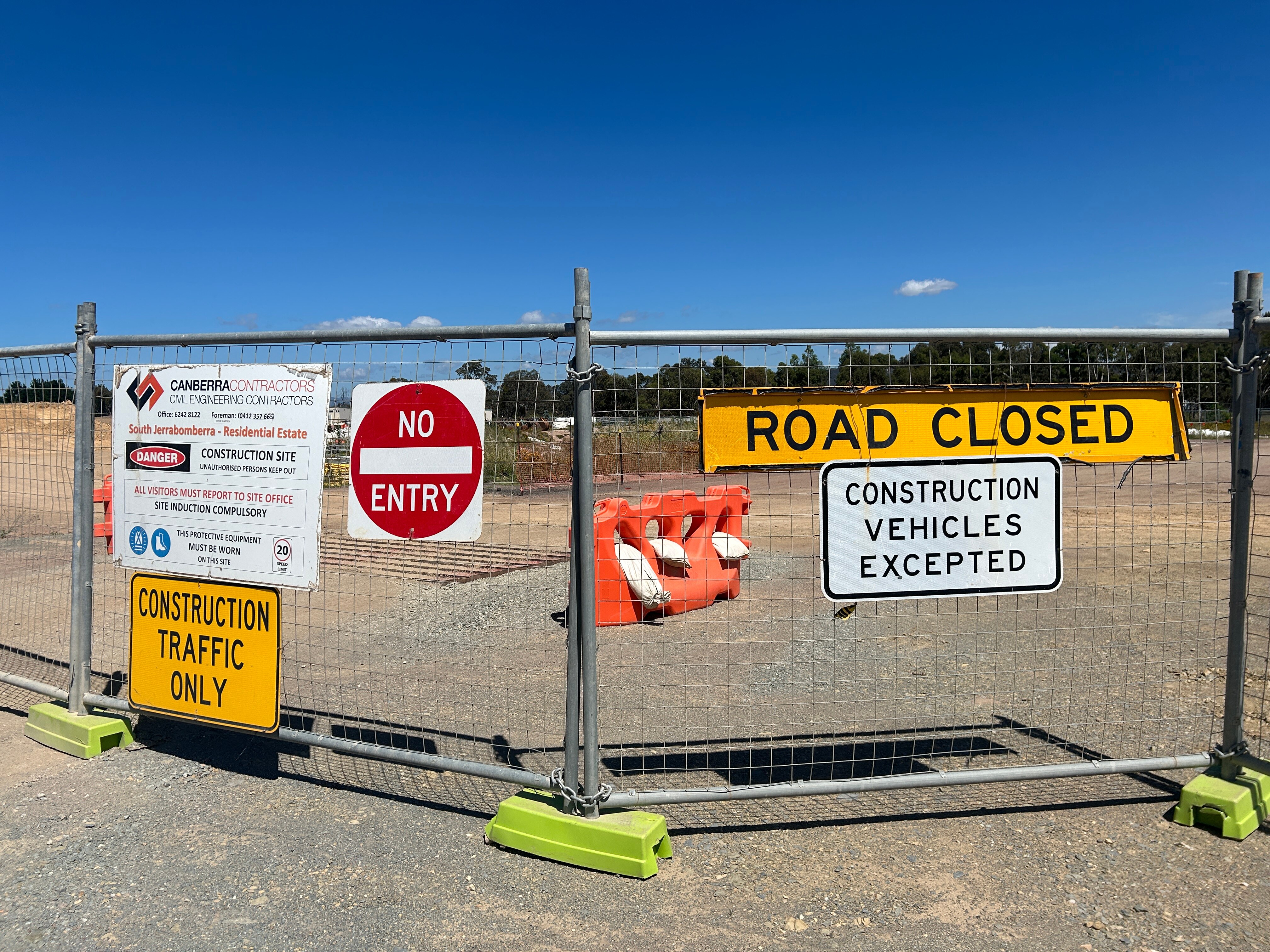 A temporary fence blocking off a road under construction.