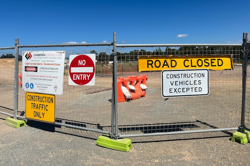 A temporary fence blocking off a road under construction.