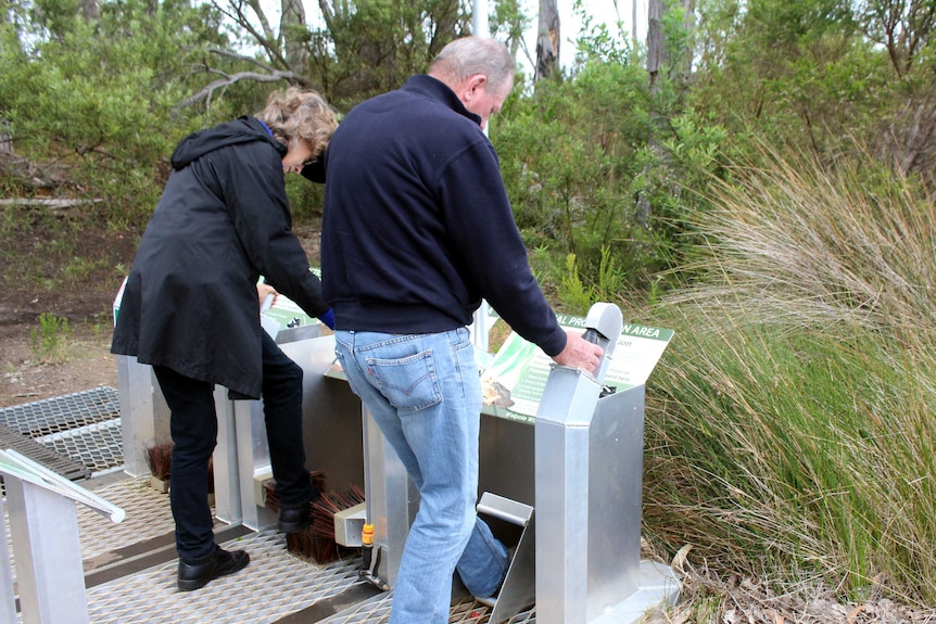 A photo of two visitors to Walpole using hygiene stations.