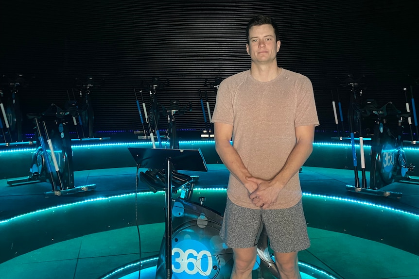 A man standing in front of exercise bikes