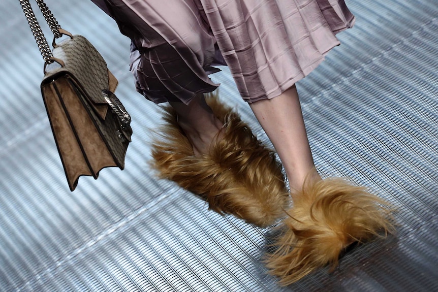 Close up of fur shoes and handbag on runway
