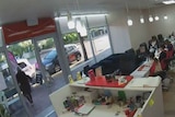 The inside of a nail salon with a woman walking out the door and about to be struck by an e-scooter rider.