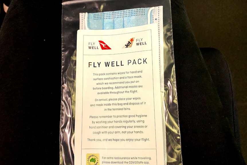 A face mask enclosed in cellophane with Qantas branding saying "Fly Well Pack".