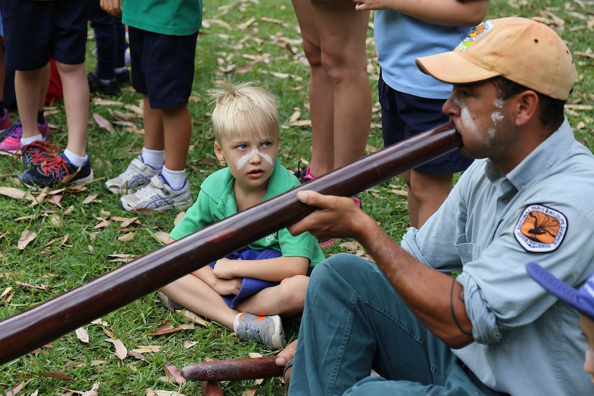 Boy watches Nigel Stewart play didgeridoo