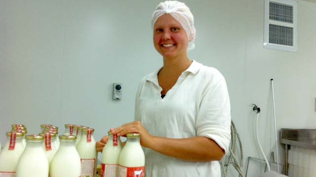 A worker bottles milk at Red Cow Dairy