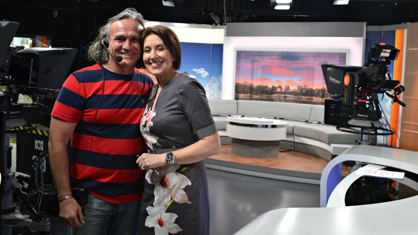ABC presenter Virginia Trioli and floor manager Joe Sumic hug on set.
