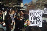 Crowds hold up signs during a Black Lives Matter rally