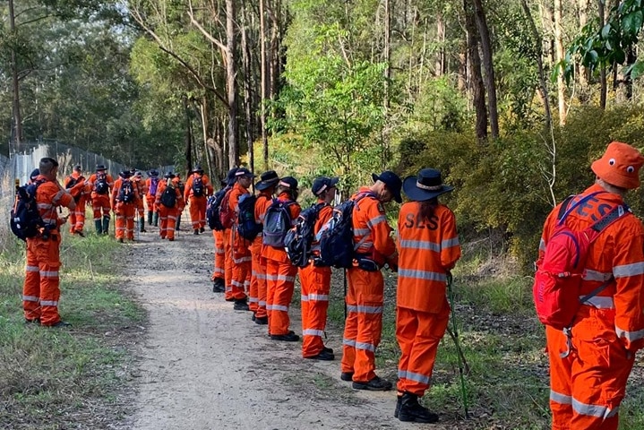 Dozens of SES volunteers line up, preparing to search bush at Dularcha National Park.