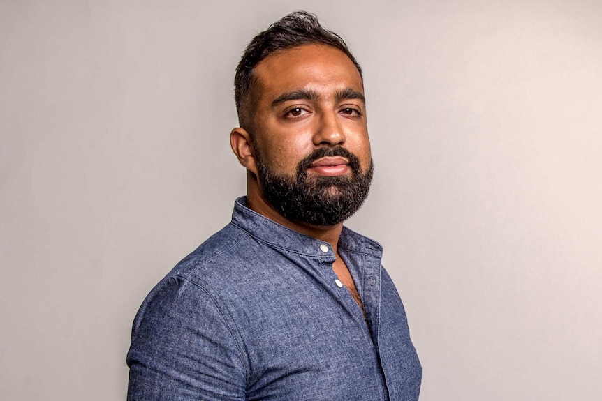 Osman Faruqi photographed in a studio, looking at the camera. He shares how you can support marginalised people in Australia.