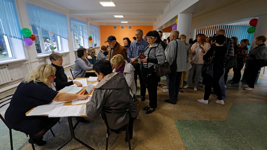 People wait in line to receive their ballots at a polling station