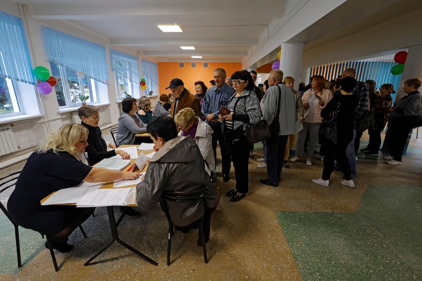 People wait in line to receive their ballots at a polling station