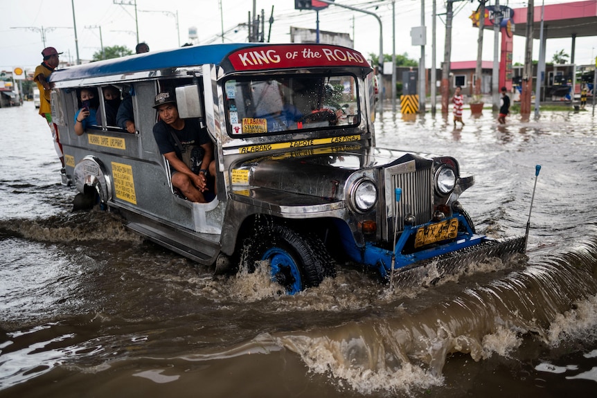 A jeepney drives through a flooded road in Manila