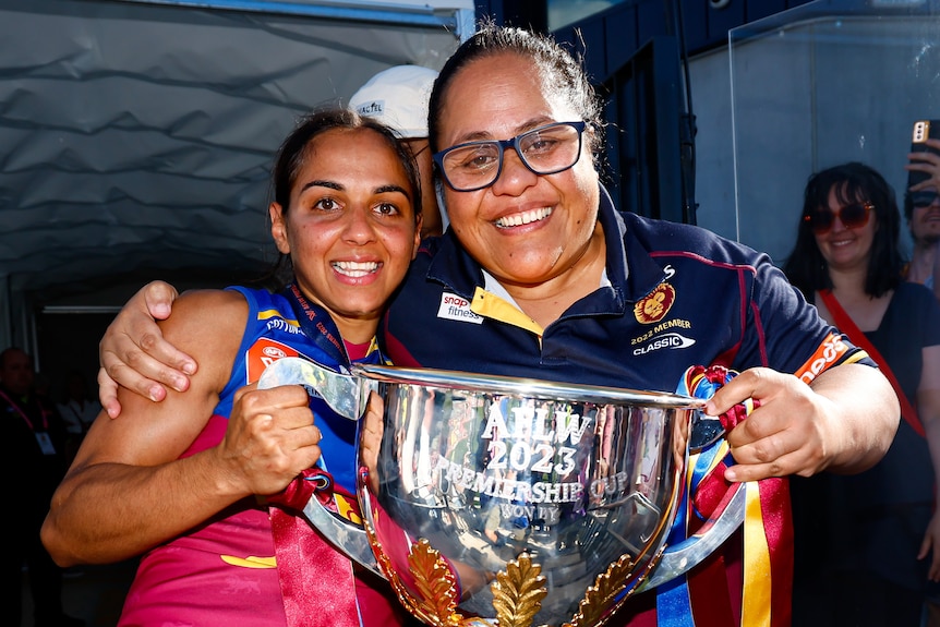 Courtney Hodder of the Lions is pictured holding the 2023 AFLW Premiership cup with her Mum