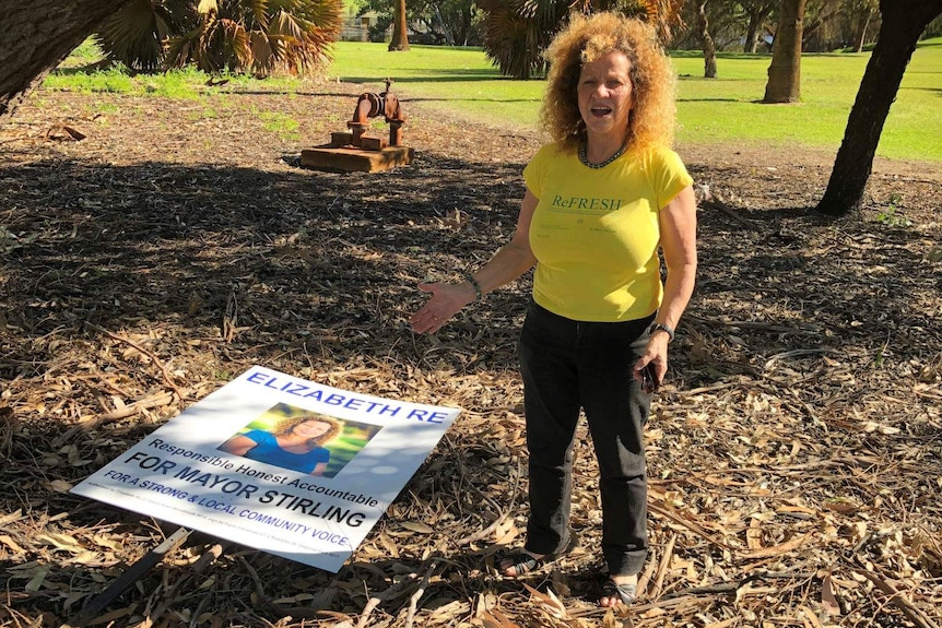 An electoral sign on the ground in a park.