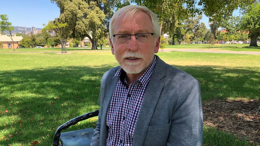 Geoff Harris sits on a park bench.