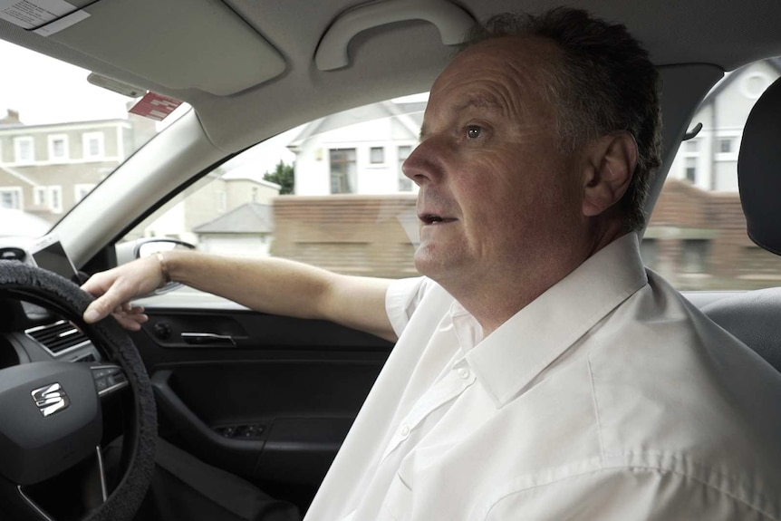 Taxi driver Paul Praid in his car in the Welsh town of Bridgend