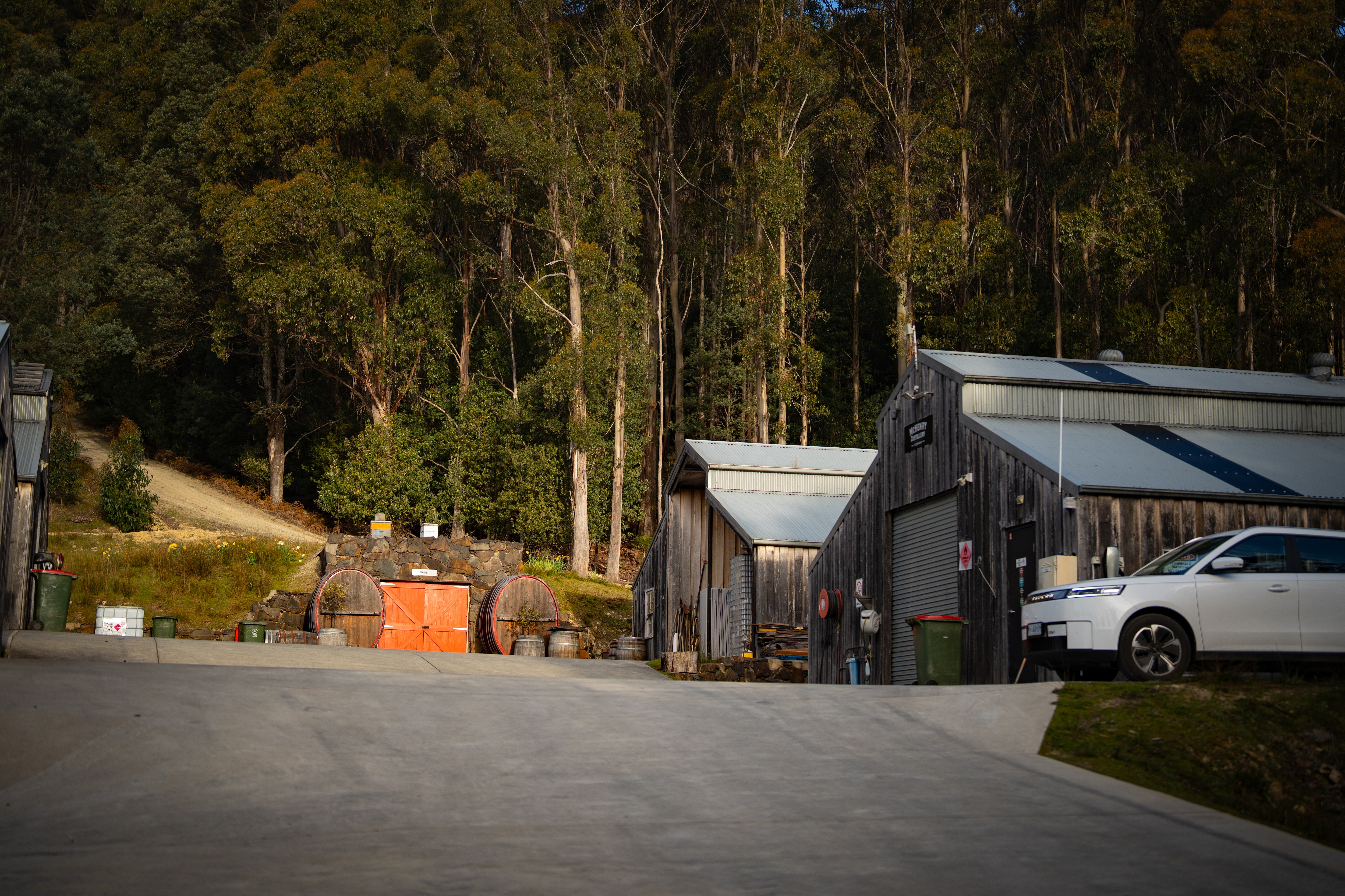 Barrels and a copper still in a modern looking large shed