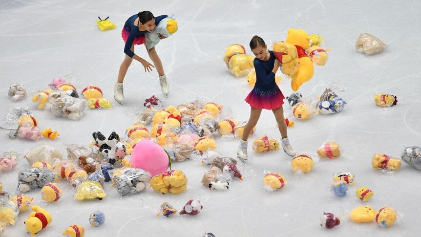 Winnie the Pooh plush toys are scattered along the ice