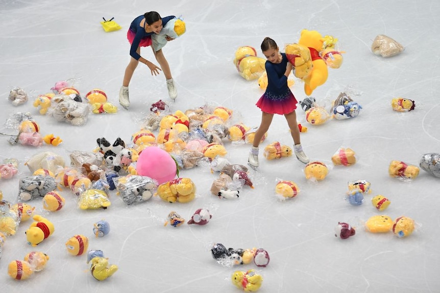 Winnie the Pooh plush toys are scattered along the ice