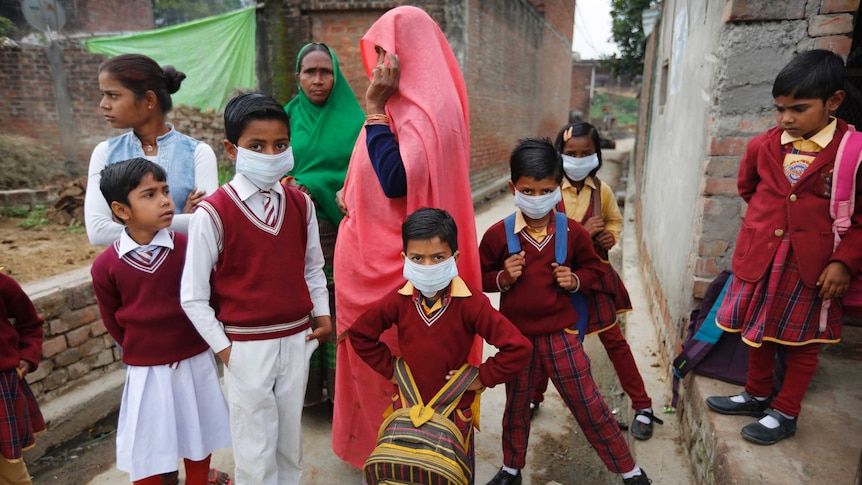 A group of Indian school children with their mothers in a laneway