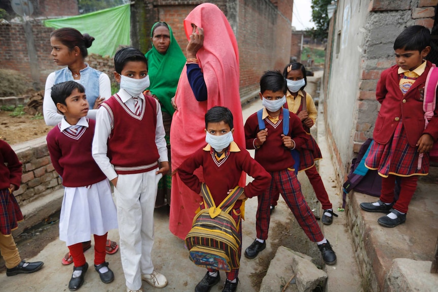 A group of Indian school children with their mothers in a laneway