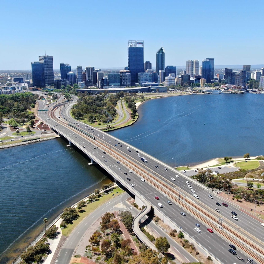 An aerial shot overlooking the Narrows Bridge, Mitchell Freeway, Swan River with the Perth city skyline in the background.