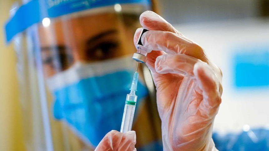 A health care worker and a syringe.