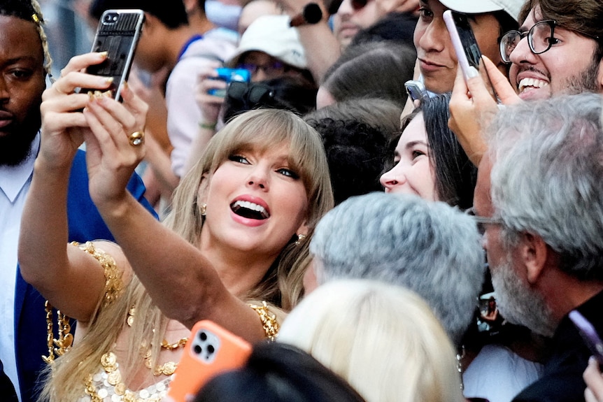 Taylor Swift poses for a selfie with fans.