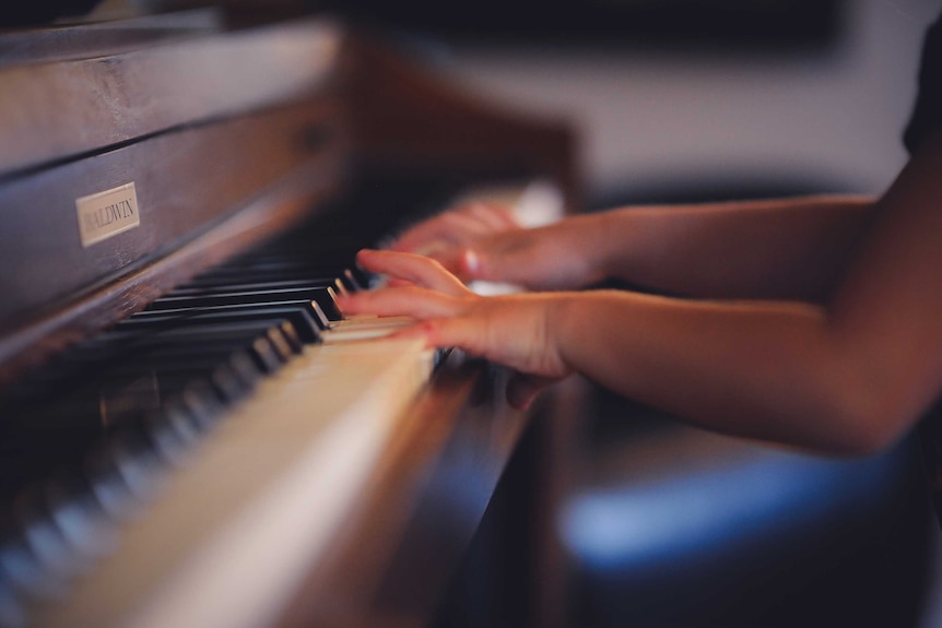 child hands at a piano