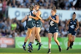 Lauren Arnell is mobbed by her Carlton teammates