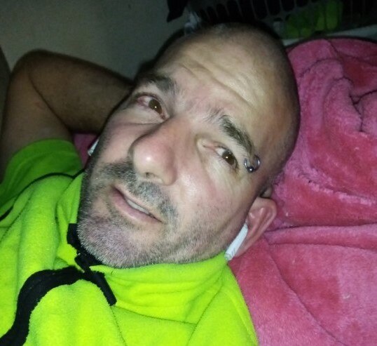 Kim Rowe with his arm behind his head lying down looking up at the camera