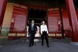 Australian Prime Minister Julia Gillard and her partner Tim Mathieson walk through a doorway at the Forbidden City in Beijing.