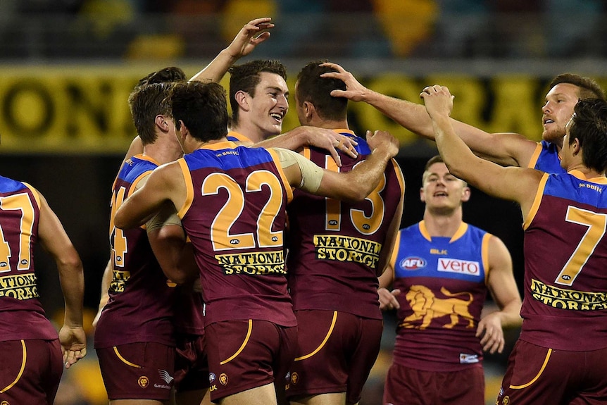Brisbane Lions players celebrate a goal against Carlton